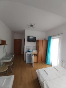 a room with two beds and a table and a kitchen at Uuli in Dźwirzyno