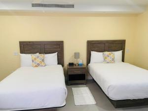 dos camas sentadas una al lado de la otra en un dormitorio en The New View Inn, en Tortola Island