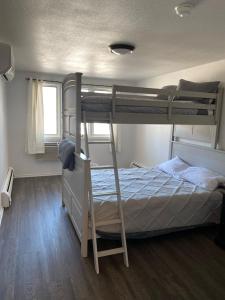 1 dormitorio con 2 literas y escalera en :::Hillsboro Inn - Apartment:::, 