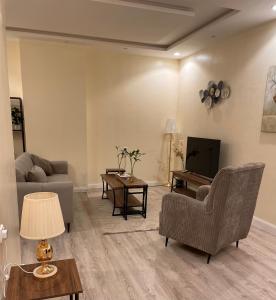 een woonkamer met een bank en een tv bij شقة دخول ذاتي بجلسة خارجيةModern Apartment North Ring 319 in Riyad