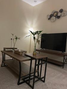 een woonkamer met een tv en een tafel met een tafel sidx sidx sidx sidx bij شقة دخول ذاتي بجلسة خارجيةModern Apartment North Ring 319 in Riyad