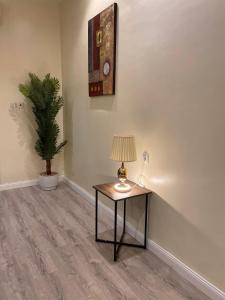 een tafel met een lamp en een plant in een kamer bij شقة دخول ذاتي بجلسة خارجيةModern Apartment North Ring 319 in Riyad