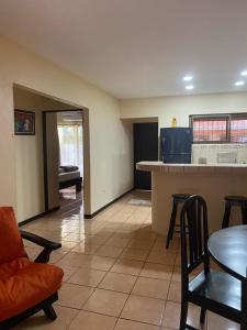 a living room with a kitchen and a table and chairs at Vista Bosque 1 in Quepos