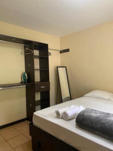 sypialnia z łóżkiem z ręcznikami w obiekcie Vista Bosque 1 w mieście Quepos