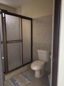 a bathroom with a toilet and a shower stall at Vista Bosque 1 in Quepos