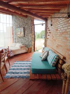 a living room with a couch and a brick wall at Tiny Houses O Olival - aluguel temporada in Cunha