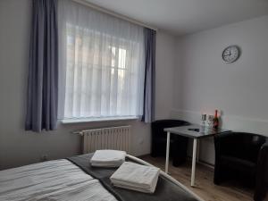 a bedroom with a bed and a table and a window at Dom Wczasowy Sloneczko in Mielno