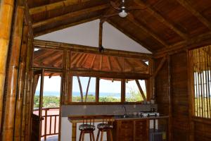 a kitchen with wooden walls and windows with a view at Bungalows Ayampe in Ayampe