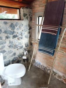 a bathroom with a toilet and a towel at Tiny Houses O Olival - aluguel temporada in Cunha