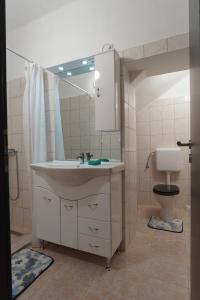 bagno con lavandino e servizi igienici di Lia Apartman Pécs a Pécs