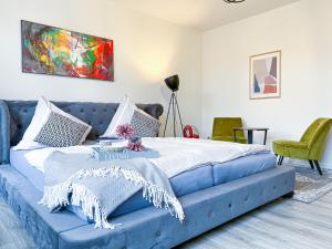 um sofá azul num quarto com uma cama em Homestayplus Schwerin em Schwerin