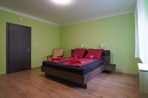 una camera da letto con un letto con cuscini rossi di Lia Apartman Pécs a Pécs
