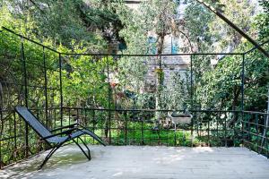 une chaise assise sur une terrasse avec une clôture dans l'établissement Rechavia Apartment, à Jérusalem