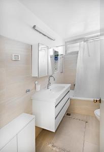 La salle de bains blanche est pourvue d'un lavabo et de toilettes. dans l'établissement Rechavia Apartment, à Jérusalem