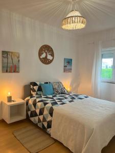Un dormitorio con una cama grande y una lámpara de araña. en Apartment Ericeira South, en Ericeira