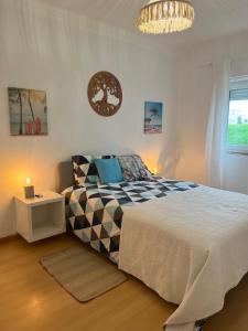 Un dormitorio con una cama grande y una lámpara de araña. en Apartment Ericeira South, en Ericeira