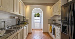 a kitchen with a sink and an arched doorway at Sugar Hill, Coconut Shell by Barbados Sothebys International Realty in Saint James