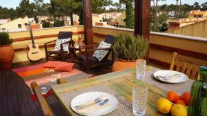 a table on a balcony with a view of a city at Forest Terrace Praia de Mira in Praia de Mira