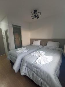 2 camas en una habitación de hotel con sábanas blancas en Novo e Fantástico Studio no Brás-Piscina, en São Paulo