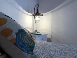 a bedroom with a bed with a pillow and a lamp at DomoMea - Le Gioie di Laura in Su Forti