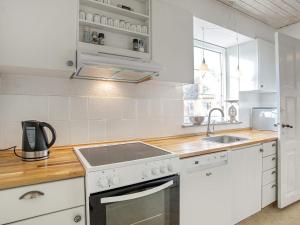 cocina blanca con fogones y fregadero en 5 person holiday home in Bandholm, en Bandholm