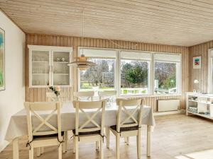 comedor con mesa, sillas y ventanas en 4 person holiday home in Dannemare, en Dannemare