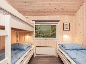 Duas camas num quarto com paredes de madeira em Holiday home Tranekær XXXIII em Tranekær