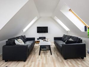 a living room with two black couches and a table at Luxury Spa Retreat by Sea in Humble