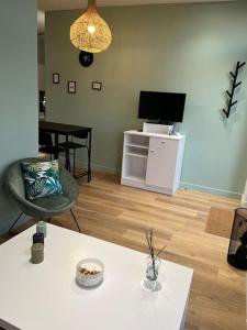 salon z białym stołem i telewizorem w obiekcie Maison Origine Périgueux w mieście Périgueux