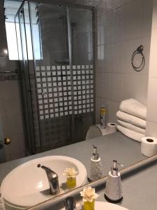 a bathroom with a sink and a shower and a mirror at Departamento La Serena in La Serena