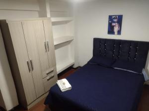 a small bedroom with a bed and a cabinet at Cerca al club militar embajada americana, Corferias 502 in Bogotá