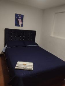 Una cama con una manta azul y una toalla. en Cerca al club militar embajada americana, Corferias 502, en Bogotá