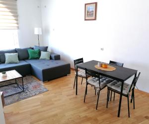 a living room with a couch and a table and chairs at Apartman Kedar in Arandelovac