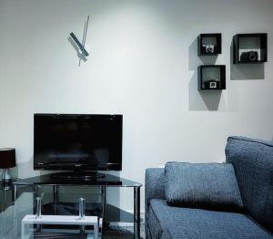 sala de estar con sofá y mesa con TV. en Two Bedroom Luxury Apt with film style, en Swansea