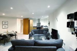 a living room with a blue couch and a table at Two Bedroom Luxury Apt with film style in Swansea