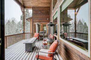 a wrap around deck with chairs and tables on it at Vista Linda Cabin in Angel Fire