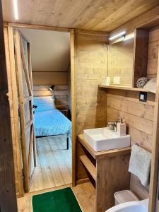 ein Bad mit einem Waschbecken und ein Bett in einem Zimmer in der Unterkunft Glamping Grancia in Grosseto