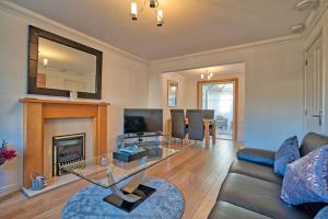 a living room with a couch and a fireplace at Three bedroom house in Culloden, Inverness in Culloden