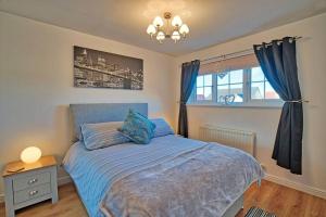 a bedroom with a blue bed and a window at Three bedroom house in Culloden, Inverness in Culloden