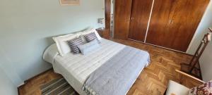 a bedroom with a bed with white sheets and pillows at Departamento temporario pateto in Cordoba