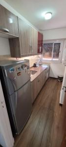 uma cozinha com um frigorífico em aço inoxidável e pisos em madeira em Departamento temporario pateto em Córdova