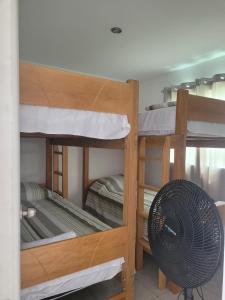 a room with three bunk beds and a fan at Fundo Chakas in San Antonio