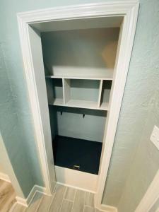 an empty closet with white shelves in a wall at MIKA SPRINGS Beach Inspired Home! in Memphis