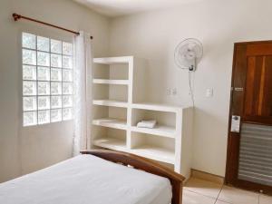 una camera da letto con scaffali bianchi, un letto e un ventilatore di Mar Adentro Sanctuary a Tola