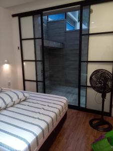1 dormitorio con 1 cama y pared de cristal en Luxo 2 suites Copacabana, en Río de Janeiro