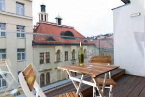 una mesa de madera en el balcón con una botella de vino en Rafael Kaiser - Aurea Apartment - Contactless 24h Check-In -, en Viena