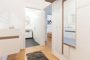 baño con armarios blancos y espejo en Rafael Kaiser - Aurea Apartment - Contactless 24h Check-In -, en Viena