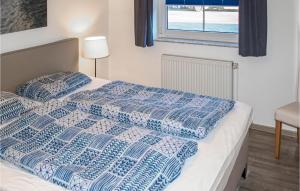 プレローにある1 Bedroom Gorgeous Apartment In Prerowのベッド1台(青と白の掛け布団、窓付)