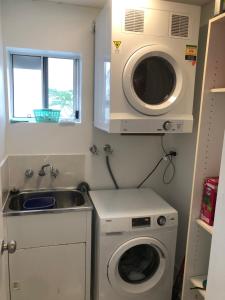 a small kitchen with a washing machine and a sink at 4shore@waterfrontplace in Maroochydore