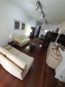 sala de estar con sofá blanco y mesa en Lindo apartamento com 2 suites, en Río de Janeiro